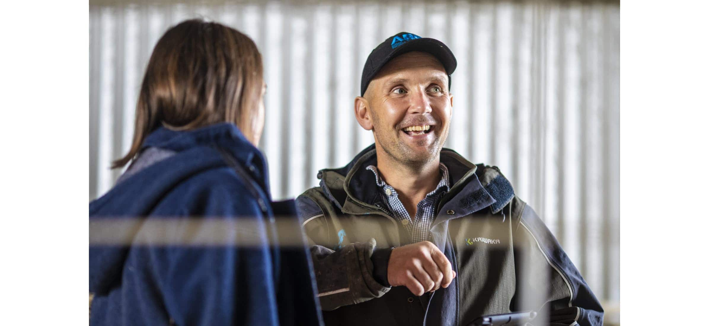 Donovan chats to Sophie in front of a corrugated wall.